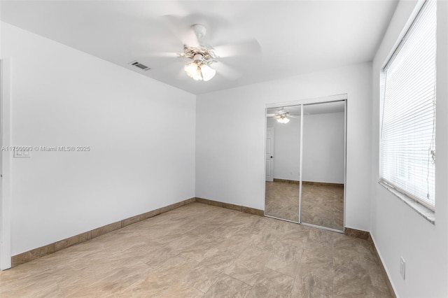 unfurnished bedroom featuring a ceiling fan, baseboards, visible vents, and a closet