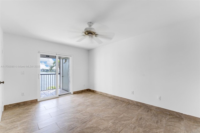 spare room featuring a ceiling fan and baseboards