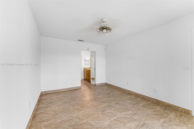 spare room featuring visible vents, stone finish flooring, and baseboards