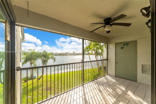 unfurnished sunroom with a water view and a ceiling fan