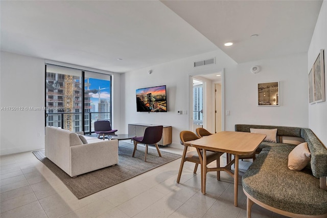 living area with recessed lighting, visible vents, and baseboards