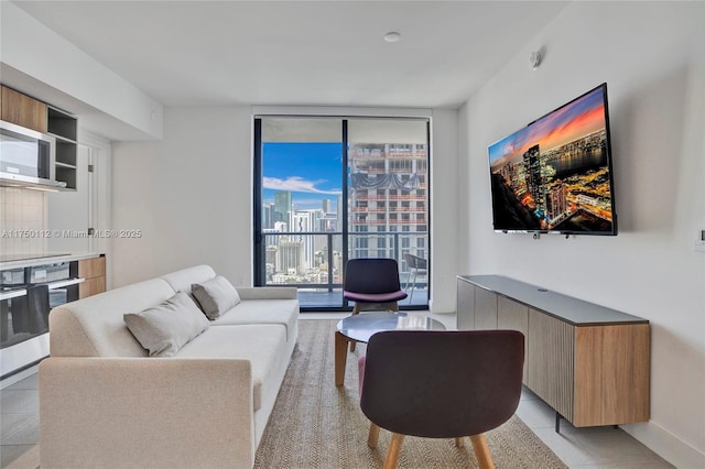 living area with light tile patterned floors, a wall of windows, and baseboards