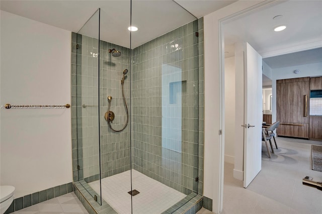 ensuite bathroom featuring tile patterned flooring, connected bathroom, toilet, baseboards, and tiled shower