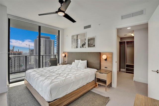 bedroom with access to exterior, a view of city, floor to ceiling windows, and visible vents