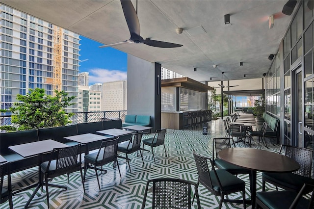 view of patio / terrace with ceiling fan, a view of city, and an outdoor hangout area