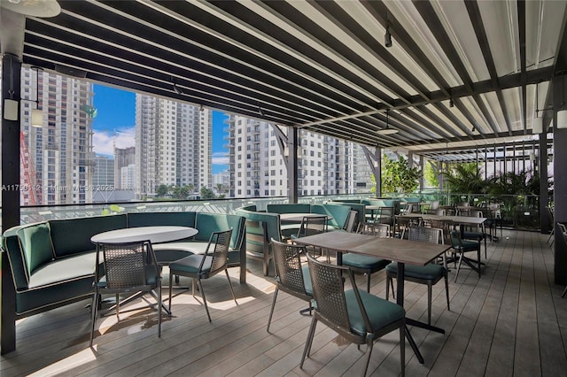 wooden deck with outdoor lounge area, a view of city, and outdoor dining area