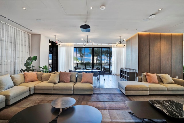 living room with dark wood-type flooring, recessed lighting, and an inviting chandelier