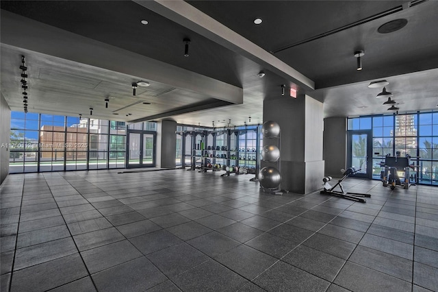 exercise room with a view of city and expansive windows