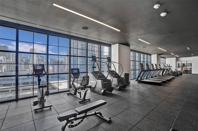 exercise room featuring floor to ceiling windows and a city view