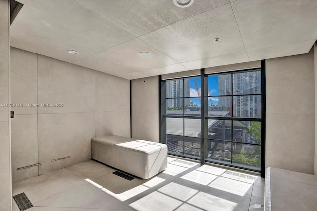 bathroom with a wall of windows and tile patterned floors