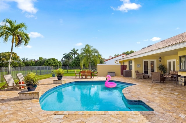 view of pool with a fenced in pool, french doors, a patio area, and fence