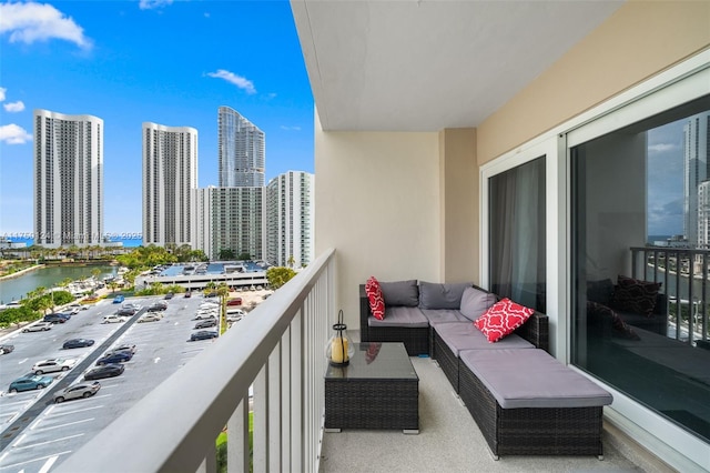 balcony with a water view, a view of city, and an outdoor living space