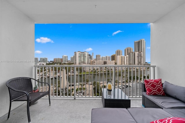 balcony with an outdoor hangout area, a view of city, and a water view