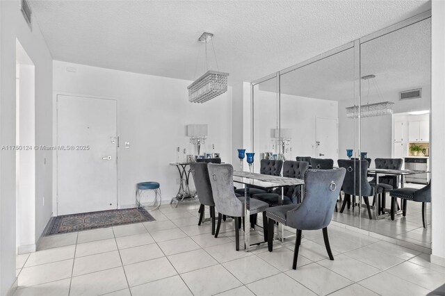 dining area featuring tile patterned flooring, visible vents, and a textured ceiling