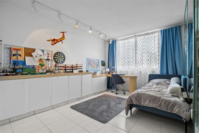 bedroom with light tile patterned floors and a textured ceiling