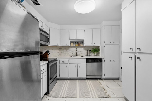 kitchen with a sink, light countertops, light tile patterned flooring, and stainless steel appliances