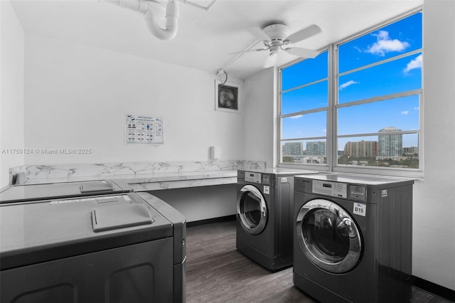 laundry room featuring laundry area, independent washer and dryer, a view of city, a ceiling fan, and dark wood-style flooring