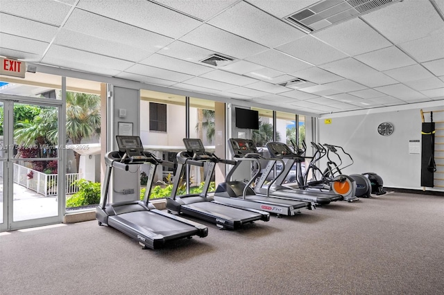 workout area featuring a wall of windows, visible vents, and a drop ceiling