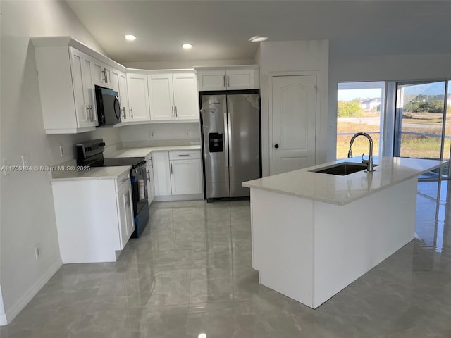 kitchen featuring light stone counters, black range with electric cooktop, a sink, white cabinetry, and stainless steel fridge