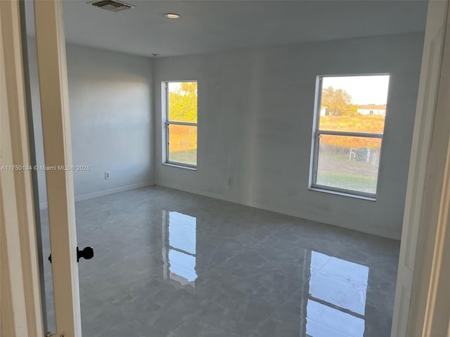 spare room featuring visible vents and baseboards