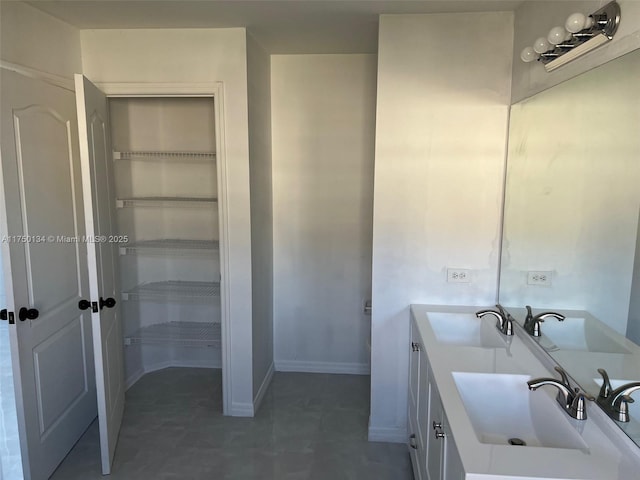 bathroom with a sink, baseboards, and double vanity