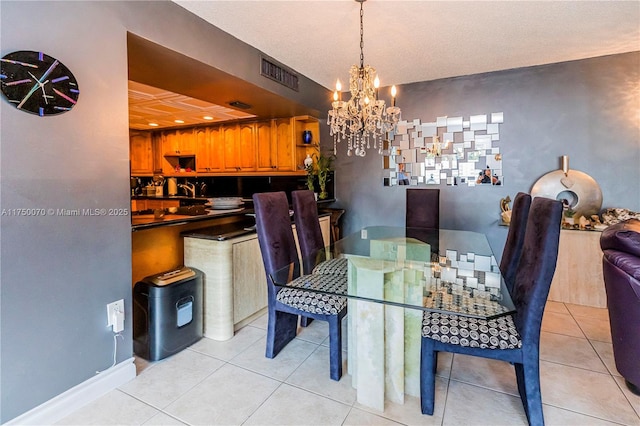 dining space featuring light tile patterned floors, baseboards, visible vents, and a notable chandelier