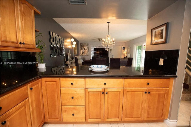 kitchen featuring a chandelier, visible vents, open floor plan, brown cabinetry, and pendant lighting