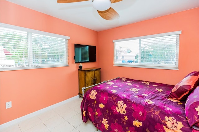 bedroom with ceiling fan, baseboards, and light tile patterned floors