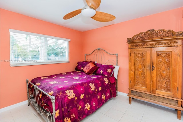 bedroom featuring light tile patterned flooring, a ceiling fan, and baseboards