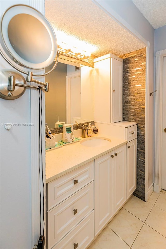 bathroom with a textured ceiling, tile patterned flooring, and vanity