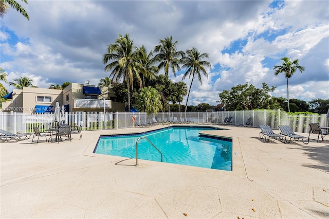 community pool featuring fence and a patio