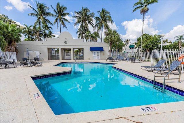 community pool with fence and a patio