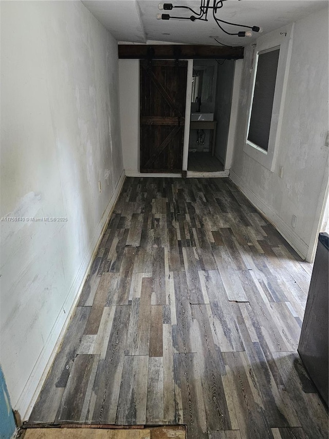 interior space with dark wood-style flooring and a barn door