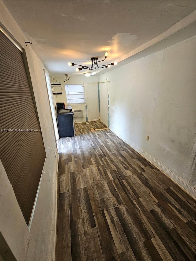 unfurnished living room with dark wood-type flooring and a wall mounted AC