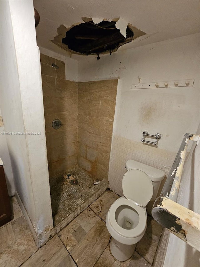 bathroom featuring toilet and a shower stall