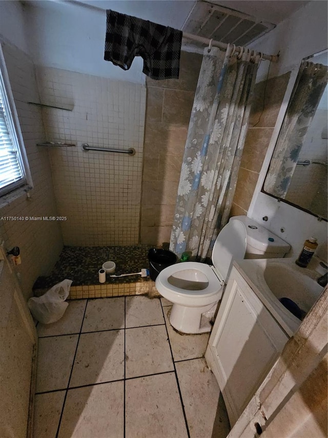 bathroom featuring toilet, a stall shower, tile patterned flooring, and vanity