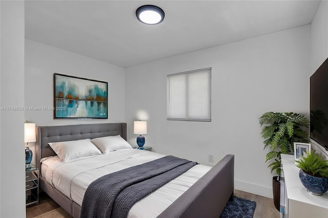 bedroom with baseboards and wood finished floors