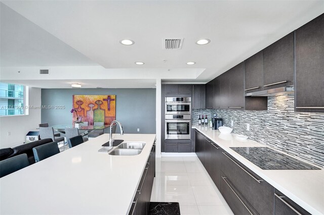 7825 NW 107th Ave Unit 604, Doral, FL 33178 - kitchen featuring a sink, light countertops, recessed lighting, decorative backsplash, and stainless steel double oven