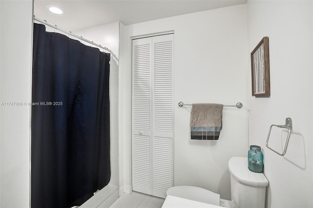 bathroom featuring a closet, toilet, and a shower with shower curtain