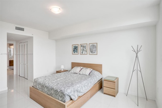 bedroom featuring a closet, visible vents, tile patterned flooring, and baseboards