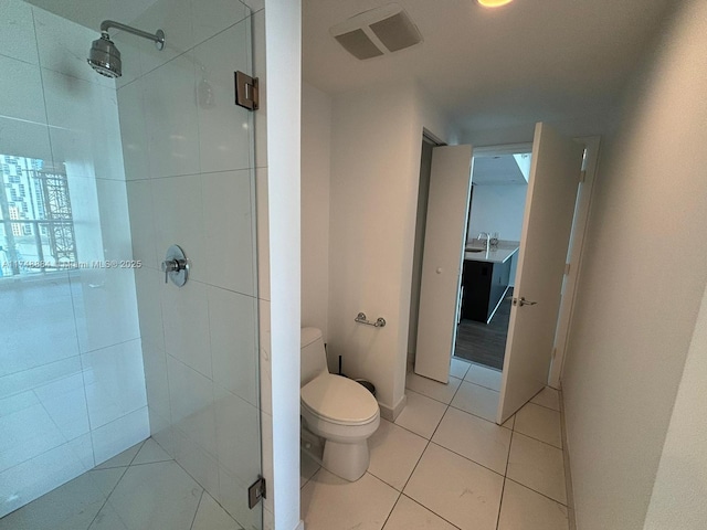 bathroom with visible vents, toilet, a stall shower, a sink, and tile patterned floors