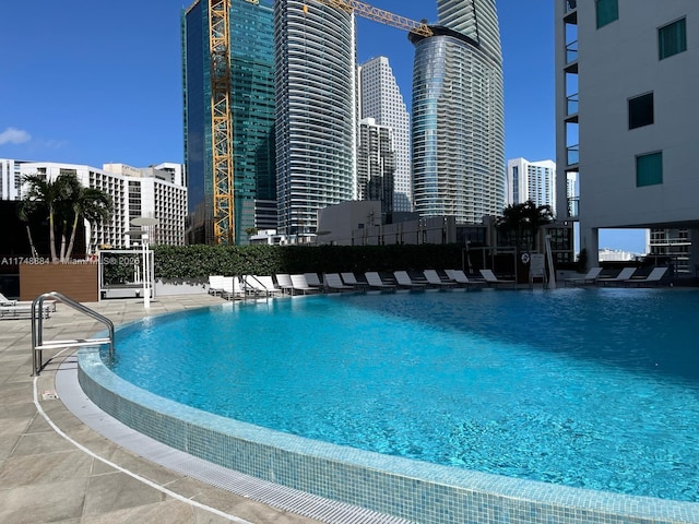 pool featuring a view of city, fence, and a patio