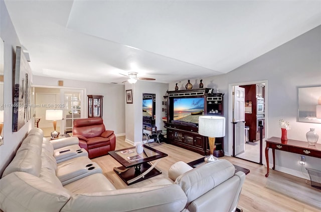 living room with lofted ceiling, ceiling fan, light wood-style flooring, and baseboards