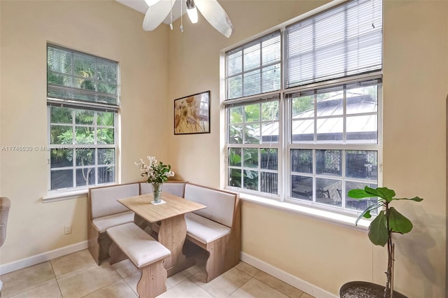 dining room featuring light tile patterned flooring, a wealth of natural light, and baseboards