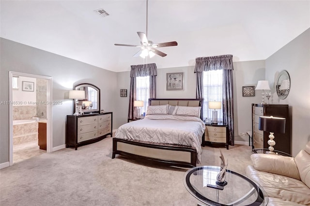 bedroom with connected bathroom, light colored carpet, visible vents, and vaulted ceiling