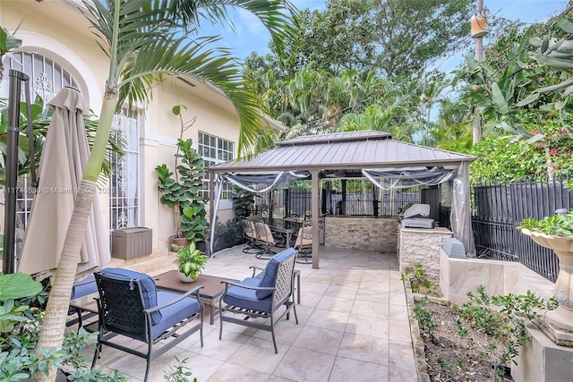 view of patio / terrace with a gazebo, exterior kitchen, an outdoor bar, and fence