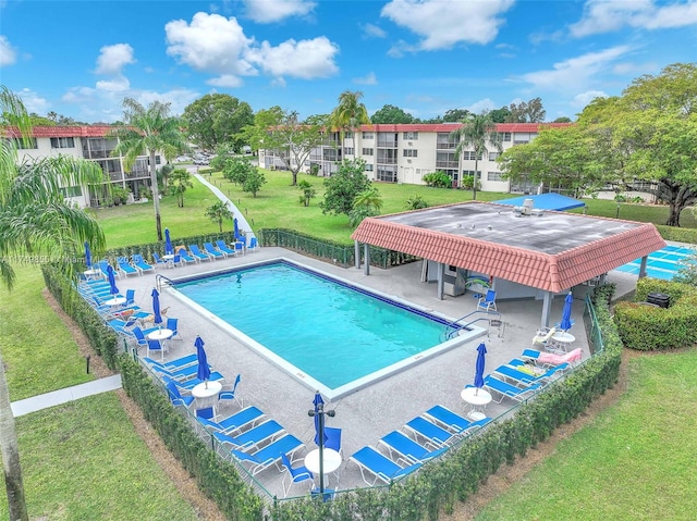 pool featuring a yard, a patio, and fence