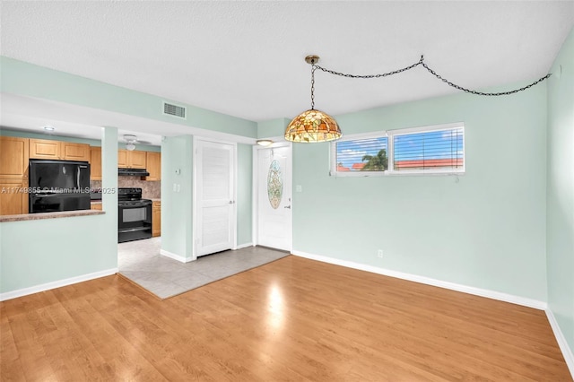 interior space featuring light wood-style flooring, visible vents, and baseboards