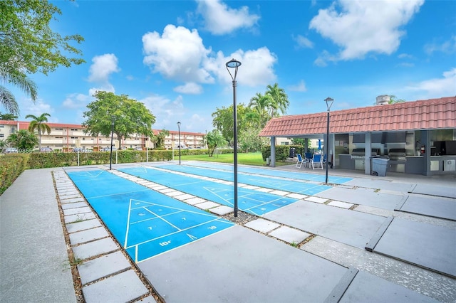 surrounding community with an outdoor kitchen and shuffleboard