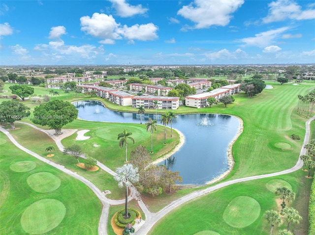 drone / aerial view featuring golf course view and a water view